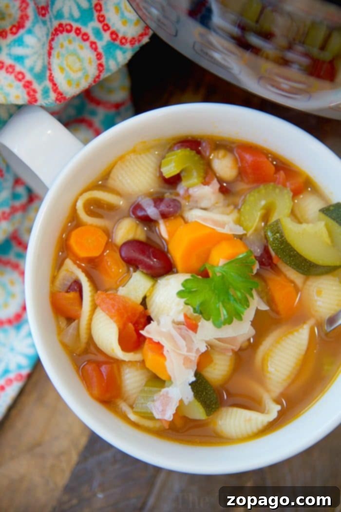 Hearty Instant Pot Minestrone Soup: A delicious pressure cooker vegetable soup with pasta, ready in minutes! A close-up shot of easy Instant Pot minestrone soup, brimming with pasta shells, colorful carrots, tender zucchini, various beans, and a fresh parsley garnish, all perfectly cooked and ready to serve.