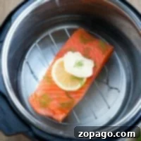 Salmon fillet with lemon and dill, topped with butter, an ideal pressure cooker fish recipe.