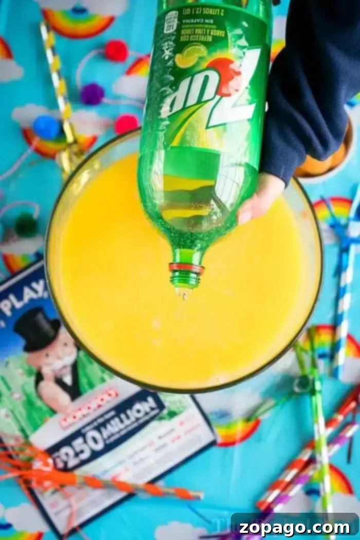 Transform any gathering into a vibrant celebration with this incredibly easy 3-ingredient party punch. Perfect for birthdays, baby showers, or any fun occasion, featuring sherbet, Sprite, and your favorite juice for a delicious, customizable drink. #PunchRecipe #SherbetPunch #EasyDrinks #PartyIdeas A hand gracefully pours 7UP into a large, elegant bowl already filled with a bright yellow liquid, indicating the creation of a festive party punch. The scene is set on a table adorned with a cheerful rainbow-themed tablecloth, alongside an array of colorful straws and a classic Monopoly game board, suggesting a fun and lively gathering. This image captures the simple yet exciting moment of preparing a signature party drink.