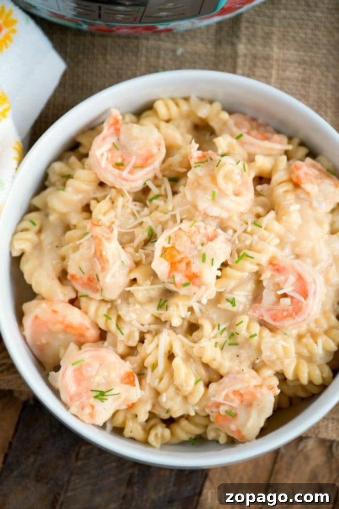 Creamy Instant Pot Shrimp Alfredo pasta with spiral noodles and fresh parsley garnish