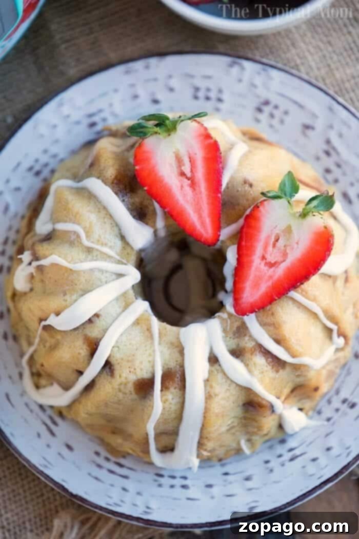 Instant Pot bread pudding is one of our favorite pressure cooker dessert recipes! Moist and pretty in a bundt pan it will become a favorite of yours too. A bread pudding bundt cake with white icing, topped with halved strawberries, sits gracefully on a decorative plate, reminiscent of the cozy warmth that instant pot bread pudding brings to a home.