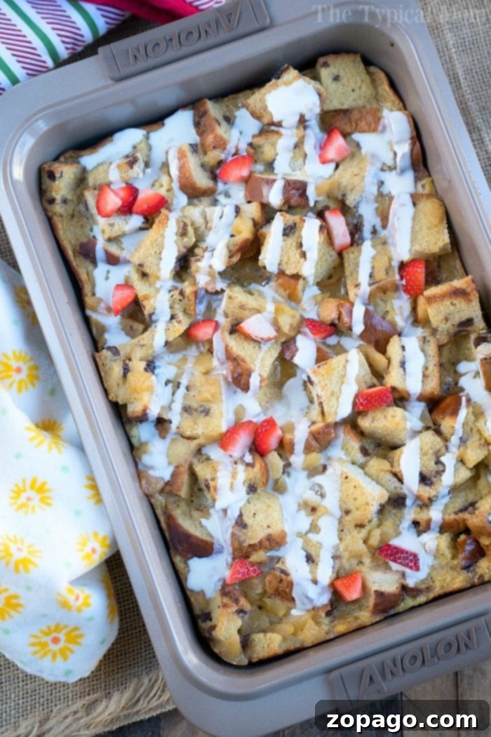 Homestyle Raisin Bread Pudding 5 A close-up of a rustic Raisin Bread Pudding with a golden-brown top, served in a white baking dish.