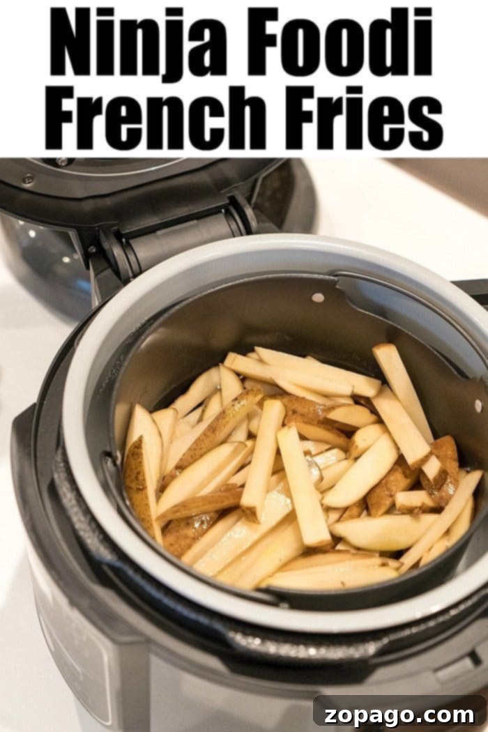 Ninja Foodi Perfect Crispy French Fries 5 Freshly cut potatoes, precisely sliced into perfect strips, arranged on a cutting board and ready for the Ninja Foodi to be transformed into crispy French fries.
