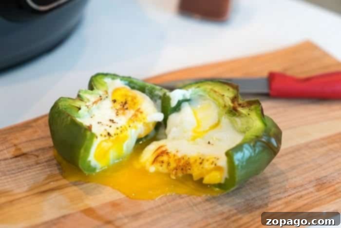 Air Fryer Breakfast Egg Perfection Close-up of an air-fried egg in a bell pepper, showing a slightly firm but still moist egg yolk surrounded by a bright green pepper, perfect for a hearty breakfast.