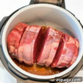 Raw beef roast, perfectly seasoned with salt, sits in an open pressure cooker, ready to transform into a delicious meal using the Ninja Foodi roast recipe.