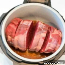 Raw beef roast, perfectly seasoned with salt, sits in an open pressure cooker, ready to transform into a delicious meal using the Ninja Foodi roast recipe.