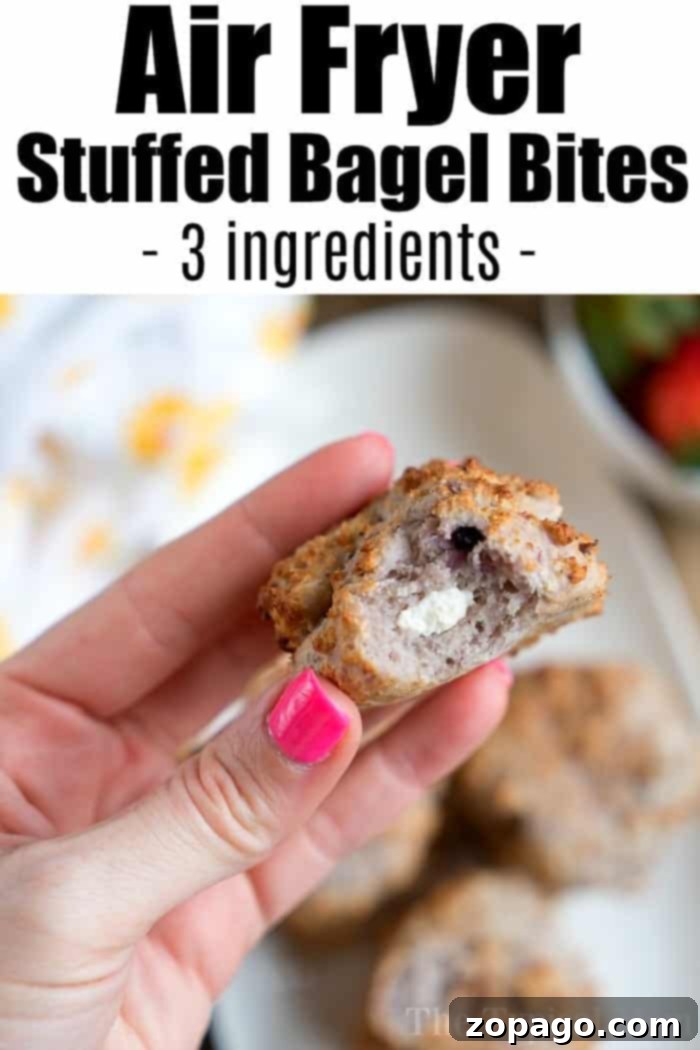 Air Fryer bagels come out crispy with a soft chewy center and can be made into stuffed bagel bites which we love. Easy 2 ingredient bagel recipe included. #airfryerbagels #airfryer #bagelbites #ninjafoodi #bagels #2ingredient #ninjafoodirecipes #airfryerrecipes #thetypicalmom A hand holding a stuffed bagel bite with a creamy filling; text reads Bagel Bites Air Fryer - 3-ingredient Air Fryer Stuffed Bagel Bites.
