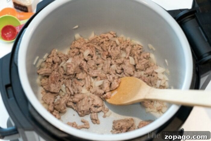 Ninja Foodi One-Pot Taco Pasta 3 A serving of taco pasta in a white bowl, garnished with fresh cilantro.