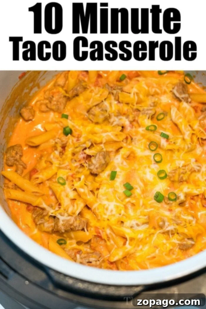 Ninja Foodi cheesy casserole with spicy sausage and pasta. A hearty taco casserole with ground meat, melted cheese, pasta, and sliced green onions, prepared in a Ninja Foodi. Text at the top reads, "10 Minute Taco Casserole."