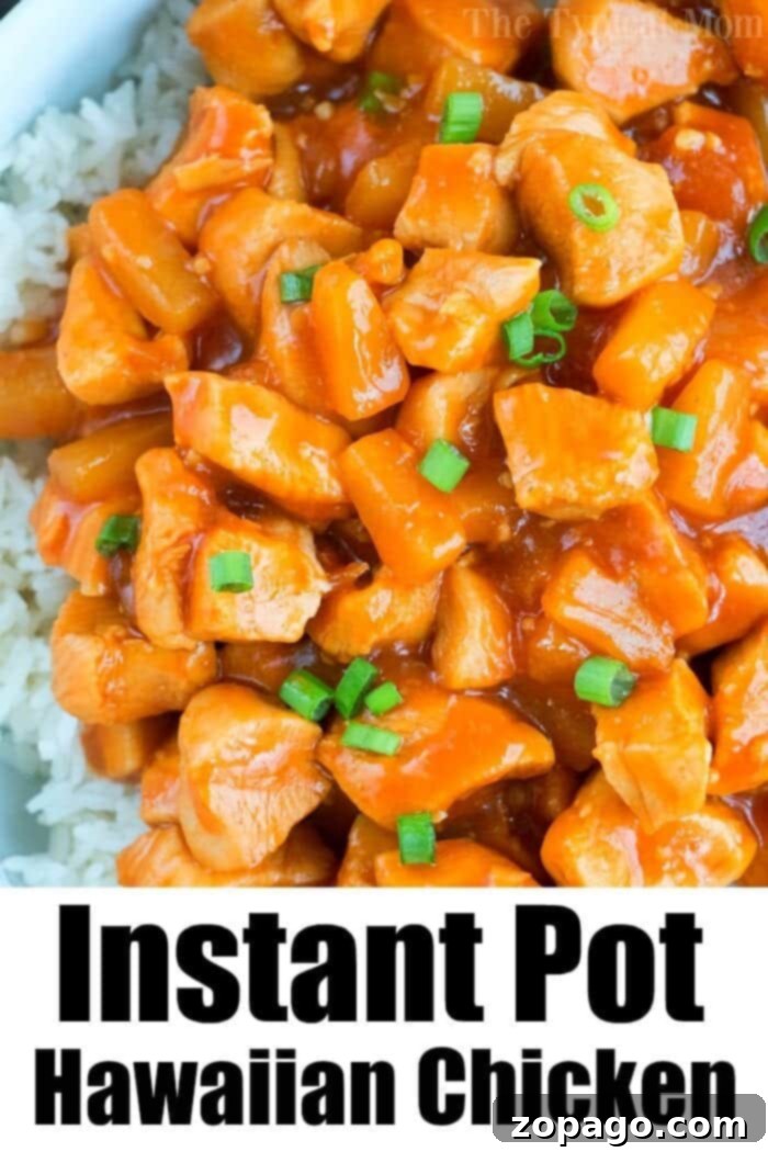 Instant Pot Hawaiian chicken is pineapple sweet with a bit of a kick. Served on top of rice or by itself it's one of our favorite pressure cooker dinners! #instantpotrecipes #instantpot #chicken #pineapple #hawaiian #sweet #thetypicalmom #ninjafoodirecipes A close-up of a serving of Instant Pot Hawaiian chicken with rice, showing the texture of the chicken and pineapple.