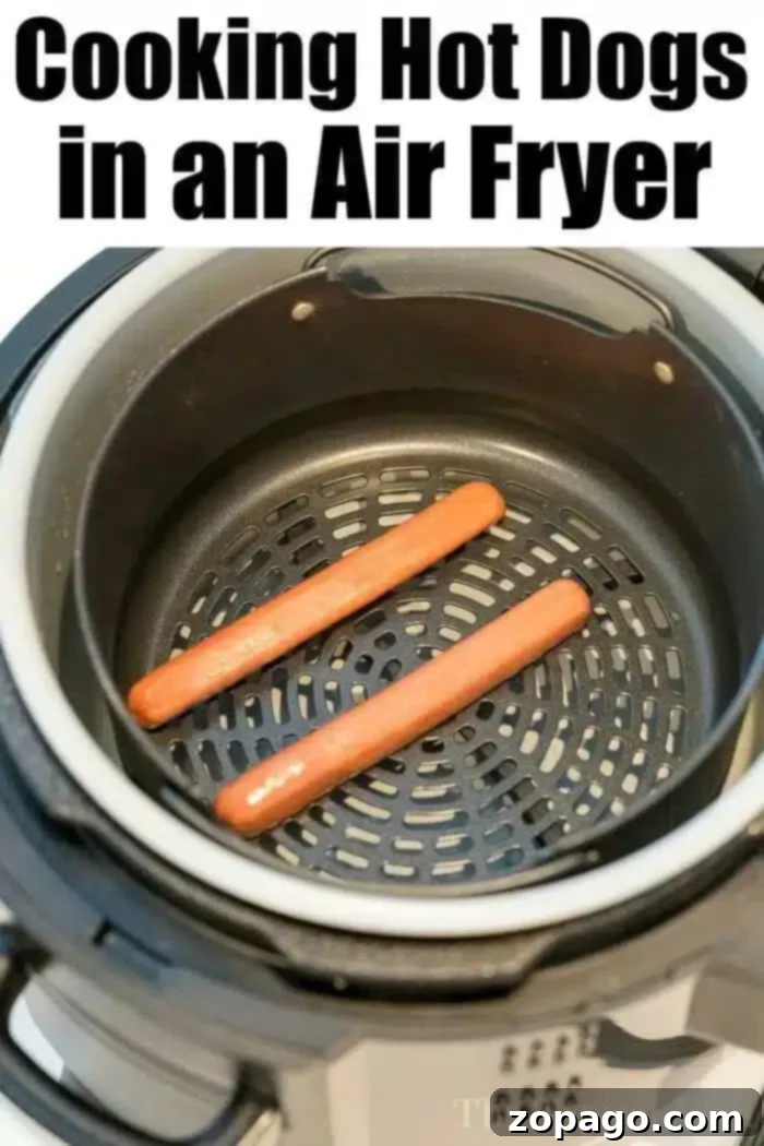 Air Fryer hot dogs or chili dogs are the perfect quick dinner idea our whole family loves! Load your buns up with toppings & they come out nice & crispy. #airfryer #hotdogs #chilidogs #ninjafoodi #ninjafoodirecipes Air fryer with two uncooked hot dogs inside. The text above the air fryer reads "Cooking Hot Dogs in an Air Fryer." The sleek black air fryer basket is clean and well-maintained.