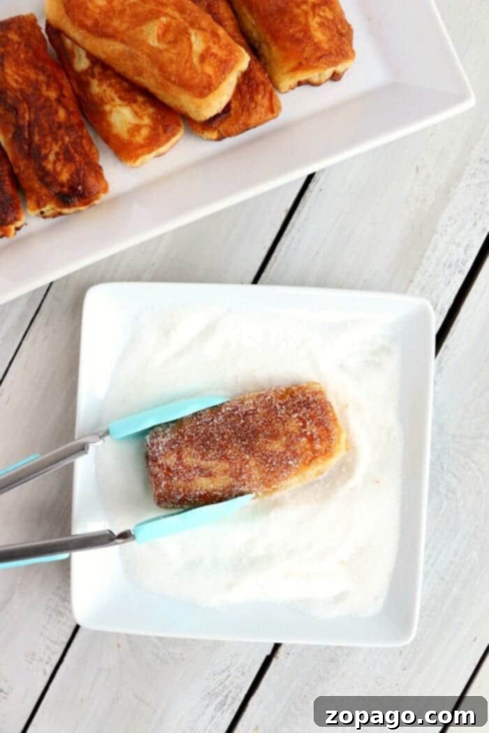 A stack of sugar-coated biscuit donuts on a white plate, showcasing their fluffy texture and golden color.