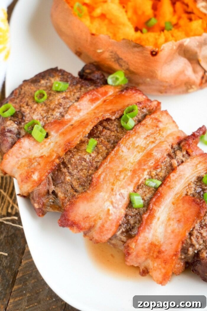 Air Fryer Steak Dinner with Sweet Potato Side Bacon-wrapped steak garnished with green onions sits elegantly beside a baked sweet potato on a white plate, reminiscent of an air fryer steak in its perfection.