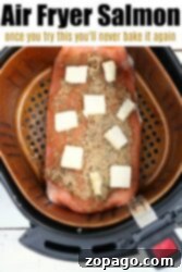 Salmon fillet cooked to perfection in the air fryer, topped with butter and seasoning. Text reads: Air Fryer Salmon Delight.
