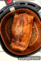 Savor the perfectly cooked salmon in the air fryer, seasoned and ready to enjoy.