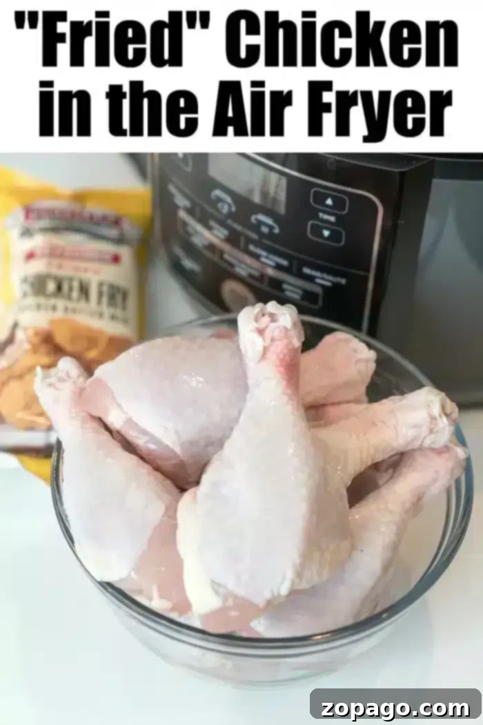 Air Fryer Fried Chicken Recipe - Raw Drumsticks and Breading A glass bowl filled with raw chicken drumsticks ready for seasoning is placed prominently in front of a modern air fryer. A package of 'Chicken Fry' mix is visible in the background. The text at the top reads, 'Fried' Chicken in the Air Fryer: Your Ultimate Air Fryer Fried Chicken Recipe, emphasizing a healthier approach to a classic dish.