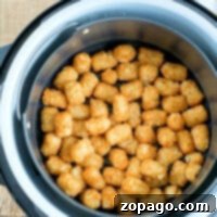 Golden and crispy, these air fryer tater tots are perfectly cooked to perfection in the basket.