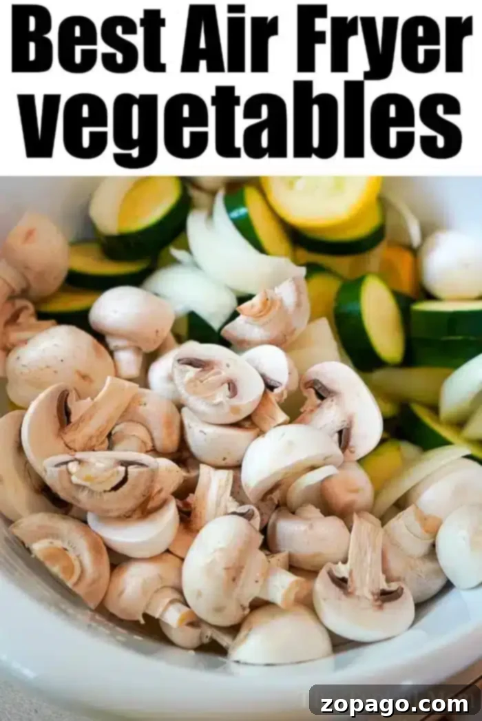Crispy Air Fryer Veggies 5 A pristine white bowl overflowing with a delicious medley of air-fried vegetables, including perfectly sliced mushrooms, zucchini, and onions. The image is accompanied by text that reads, "Best Air Fryer Vegetables," emphasizing the dish