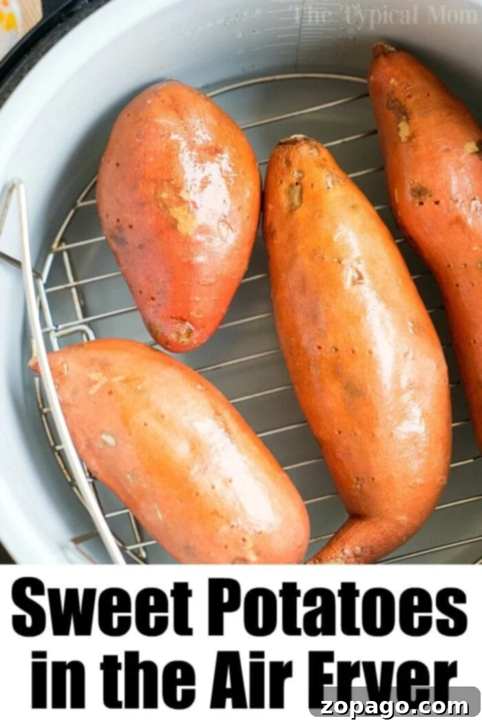 Perfect Air Fryer Sweet Potatoes 4 Four whole sweet potatoes resting on a rack inside a Ninja Foodi air fryer, ready for cooking.