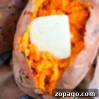 Baked sweet potato in the air fryer topped with a pat of melting butter
