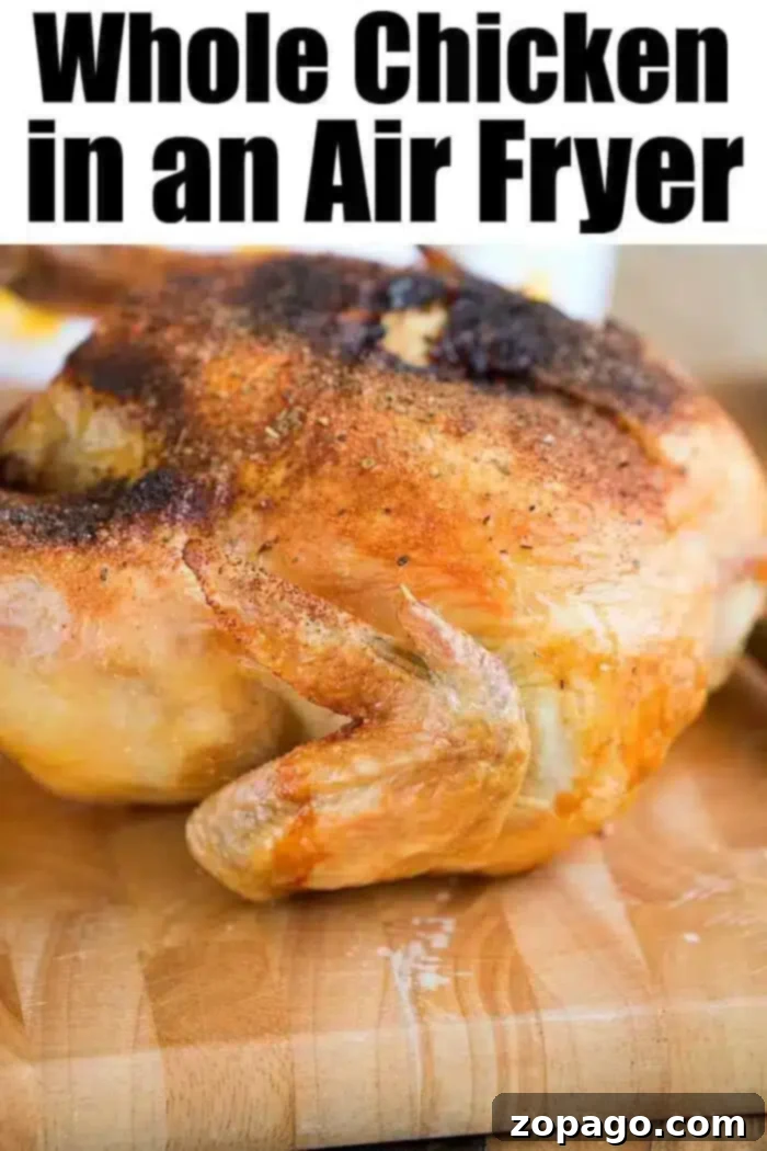 A cooked air fryer whole chicken with crispy, golden-brown skin rests on a wooden cutting board. The top text proudly declares, 'Whole Chicken in an Air Fryer,' emphasizing the ease and deliciousness of the method.