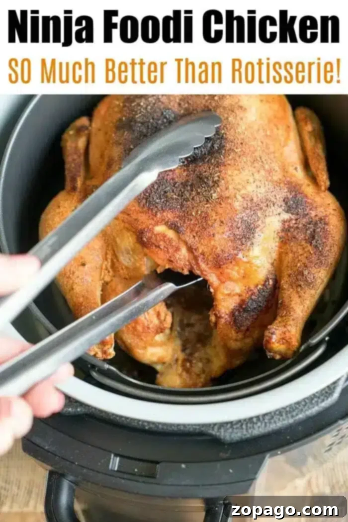 A beautifully roasted whole chicken being lifted from a Ninja Foodi multi-cooker with metal tongs. The image highlights the impressive results achievable with the appliance, with text suggesting it's 'SO Much Better Than Rotisserie!'