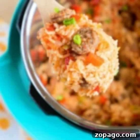 A wooden spoon scoops pressure cooker jambalaya from an Instant Pot, garnished with sliced green onions.