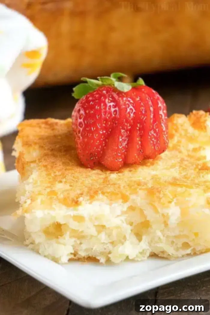 Effortless Angel Food Two-Ingredient Cookies 7 A close-up of a piece of golden-brown bread pudding on a white plate, elegantly topped with a strawberry sliced in a fan-like pattern.