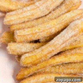 Delicious Homemade Churros 5 A plate of sugar-coated churros, freshly made from the best homemade churros recipe, stacked invitingly.