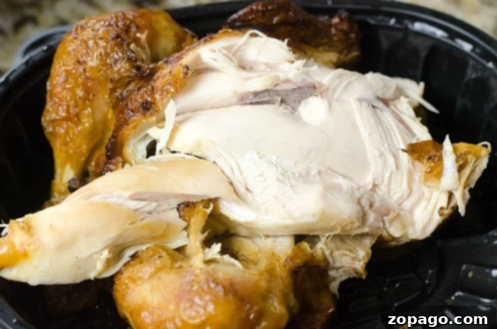 Instant Pot Comfort Soup 4 A close-up shot of a perfectly cooked rotisserie chicken inside a black plastic container. Its golden-brown skin glistens with savory juices, inviting you to shred the tender white meat for a quick and comforting Instant Pot Feel Better Soup.