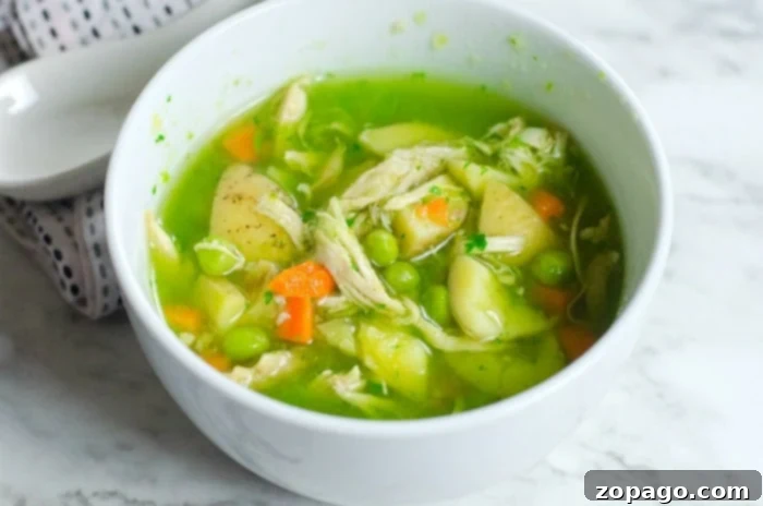 Delicious pressure cooker chicken potato soup, a hearty and easy meal. A comforting bowl of chicken and potato soup, made in a pressure cooker, is presented on a rustic wooden surface. The steam rising from the rich broth suggests its warmth and freshness, highlighting the ease and speed of pressure cooking for this wholesome dish.