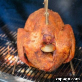A turkey is smoked to perfection on a traeger with a rotisserie attachment with a dry rub on the outside