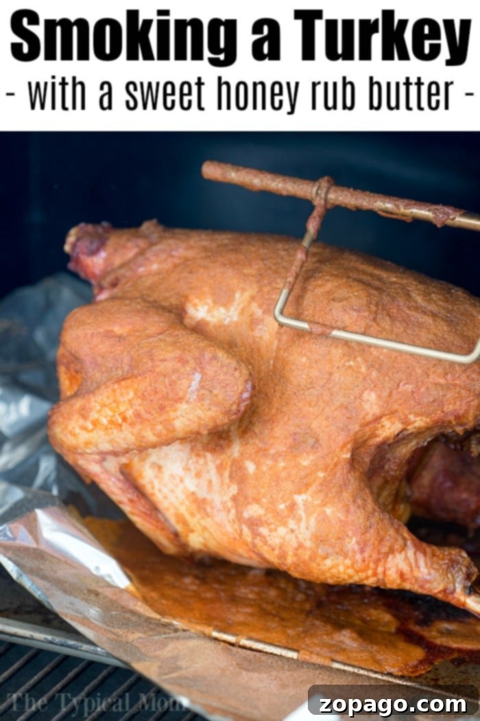 Our easy smoked turkey recipe results in a beautifully glazed and juicy bird. #turkey #smoked #butter #rub #wet #honey #thanksgiving A whole roasted turkey with golden-brown, glistening skin, garnished with fresh herbs, ready to be served.