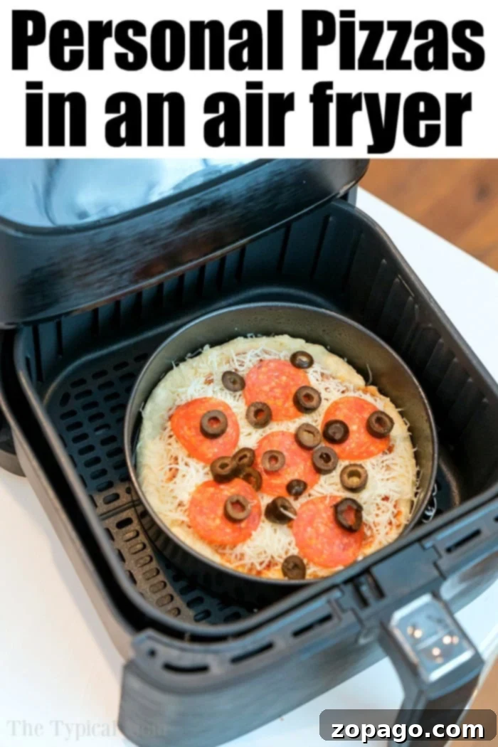 An air fryer is open, revealing a personal pizza with melted cheese, pepperoni, and black olives nestled inside, showing how easy it is to make delicious "Air Fryer Pizza".