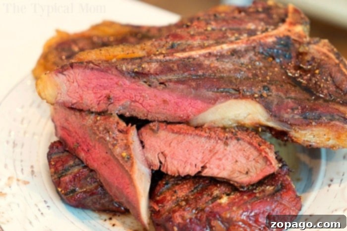 Understand the internal temperature of steaks and how to accurately check it for perfect doneness. #steaks #internaltemperature #cookingtips #beef #grilling Exquisitely sliced grilled steaks with a flavorful, seasoned crust are neatly stacked on a pristine white plate, revealing a succulent, juicy pink interior. This image perfectly illustrates the optimal internal temperature and doneness achieved when you discover how to smoke a steak to perfection, adding an extra layer of mouthwatering flavor.