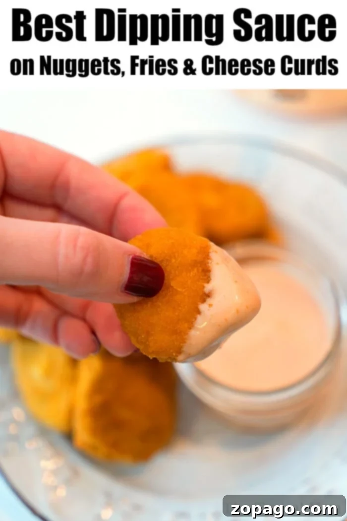A bowl of creamy fry sauce on a white plate with a side of crispy french fries and a small green garnish.