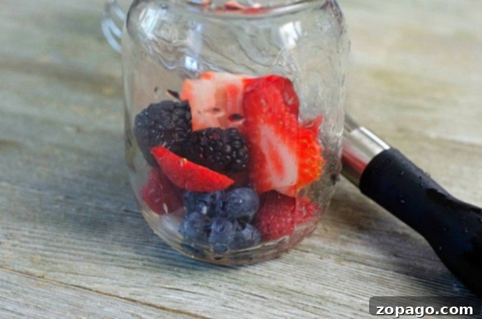 Effortless Berry Mojito 4 A glass filled with a vibrant berry mojito, garnished with fresh berries and mint