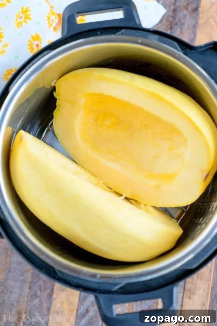 Sunshine Flavors 2 Halved spaghetti squash, a summer favorite in July instant pot recipes, sits ready on a wooden surface.