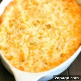 Creamy Green Chile Chicken Casserole 8 A baked casserole dish filled with creamy, golden-brown cheesy hash brown potatoes, enhanced by the savory flavors of green chile chicken.