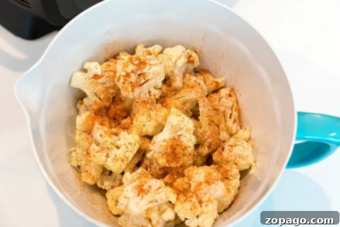Crispy Air-Fried Cauliflower 3 Crispy air fryer cauliflower florets in a Ninja Foodi basket, demonstrating the ease of preparing healthy side dishes.