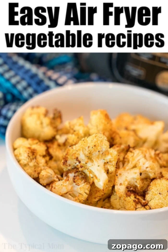 Air fryer cauliflowe. Healthy and full of flavor it's a great vegetable side dish or snack. #airfryer #ninjafoodi #cauliflower #vegetables #vegetarian #sidedish Golden brown crispy air fryer cauliflower florets in a metal air fryer basket, ready to be served.