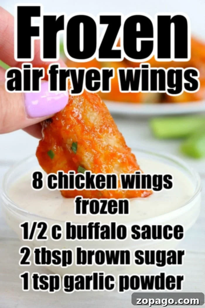Crispy Air Fryer Frozen Chicken Wings 6 Close-up of a hand dipping a buffalo chicken wing into sauce. Discover the ultimate air fryer recipe for turning frozen chicken wings into crispy, savory bites.