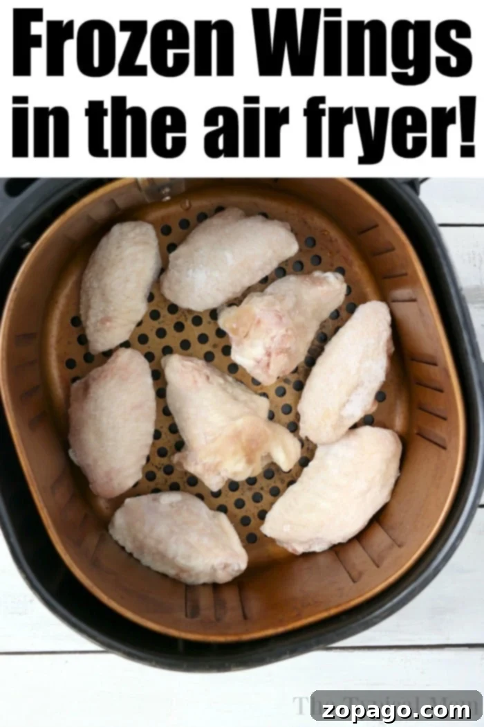 Crispy Air Fryer Frozen Chicken Wings 4 Frozen chicken wings in an air fryer basket, ready to be perfectly cooked, promise a crispy delight with minimal effort.