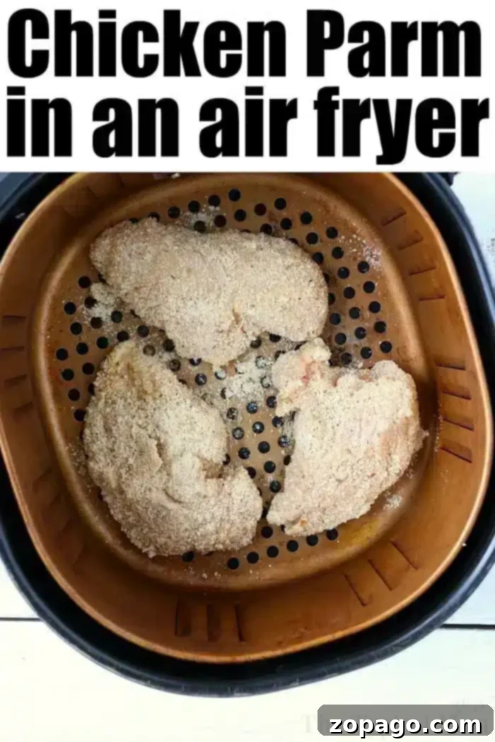 Crispy Air Fryer Chicken Parmesan Ready to Serve Air fryer basket with three breaded chicken breasts, perfectly cooked and labeled 'Air Fryer Chicken Parm' at the top.