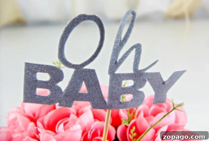 DIY Baby Shower Centerpiece Ideas 4 Detailed shot of assembling a baby shower centerpiece, showing how to insert flowers and the sign into a pool noodle base for stability.
