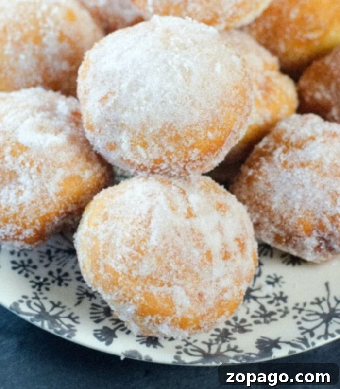 Homemade Donut Bites 2 Homemade powdered sugar donut holes beautifully arranged on a plate