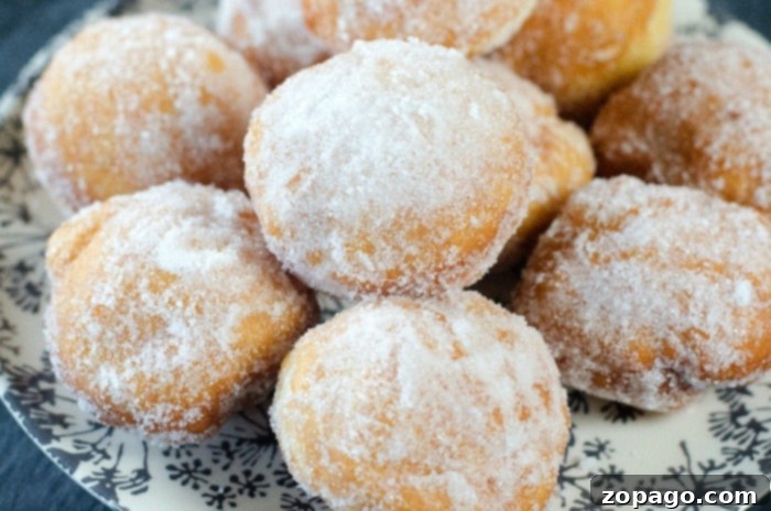 Homemade Donut Bites 3 A close-up of golden-brown homemade yeast donut holes, glistening with freshness