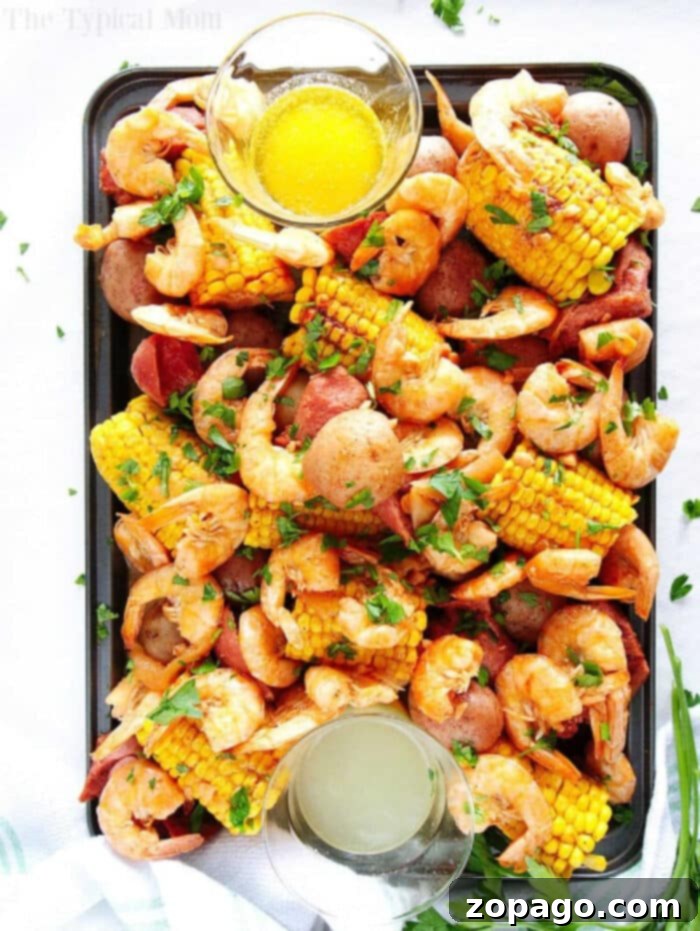 Quick Instant Pot Shrimp Boil 2 A vibrant tray of Instant Pot shrimp boil, overflowing with perfectly cooked shrimp, golden corn on the cob, red potatoes, and sliced sausage, garnished with fresh herbs and served with two bowls of dipping sauces.