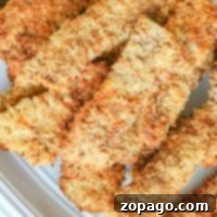 Crispy, golden-brown chicken fried steak in air fryer elegantly arranged on a white plate.Crispy, golden-brown chicken fried steak in air fryer elegantly arranged on a white plate.