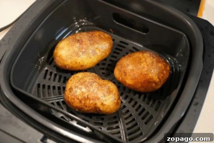 Perfect Steak on Ninja Foodi Grill 4 Crispy air fryer baked potatoes on a white platter, perfectly golden brown